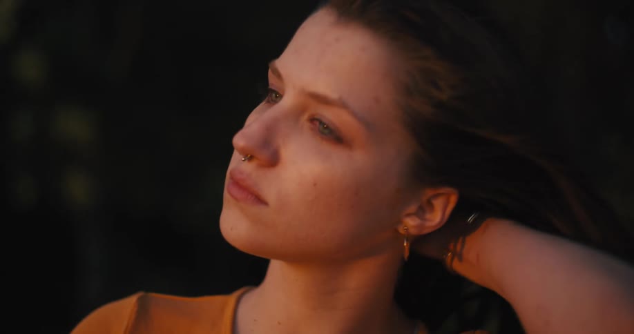 Face of a young sad woman crying at sunset