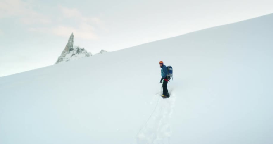 Man and woman trek on snow covered peak