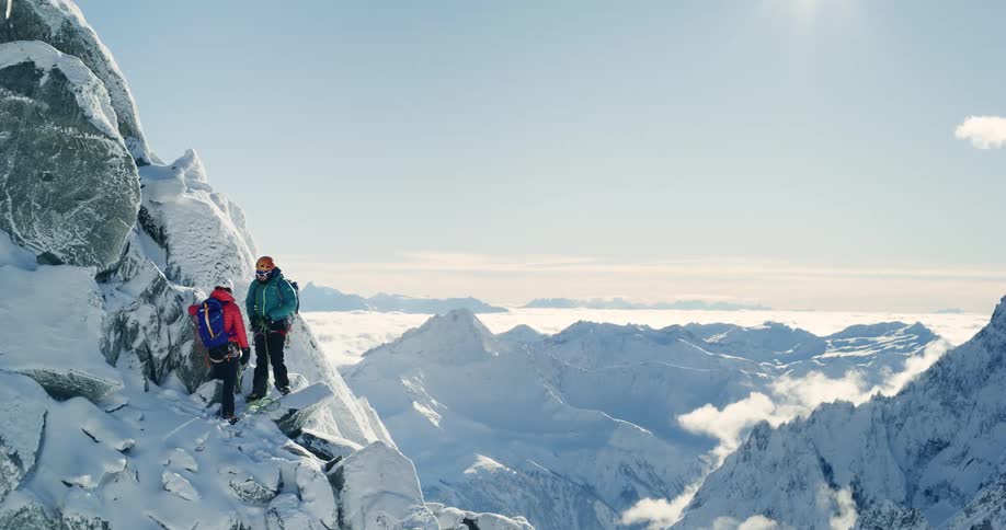 Two climbers ascending a steep snowcovered mountain