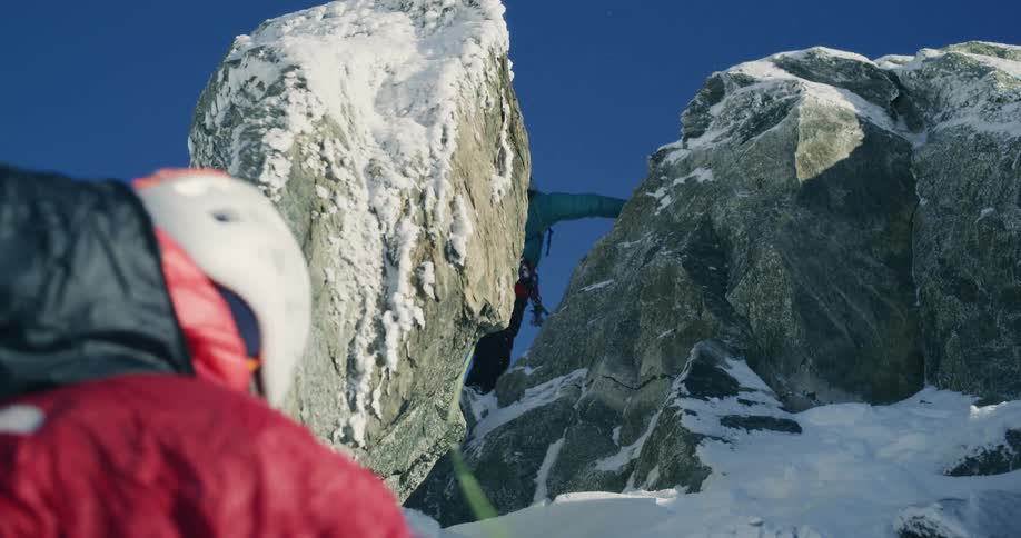 Two mountain climbers go up a steep slope