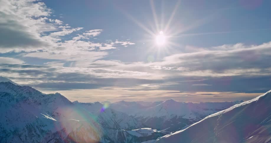 Sun shines over the snow covered mountains