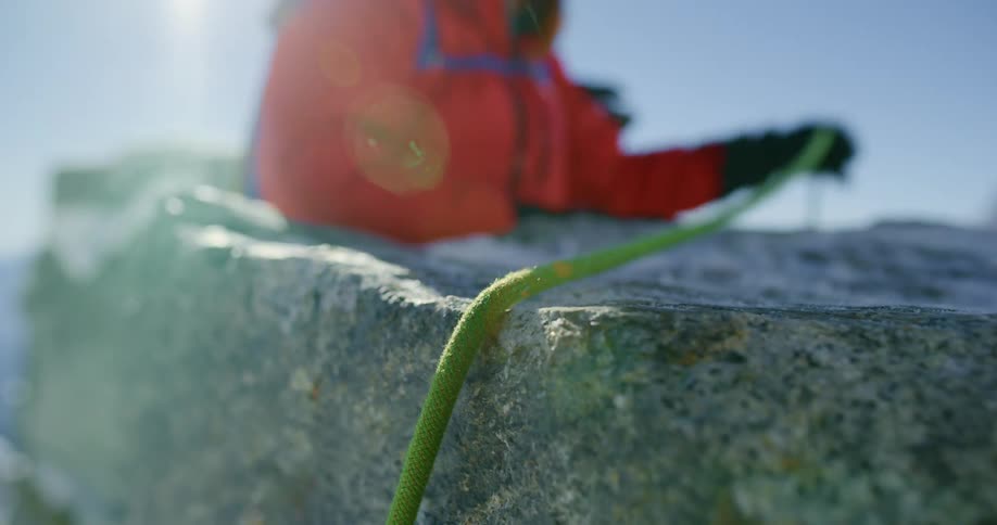 A person placing a rope on the rock