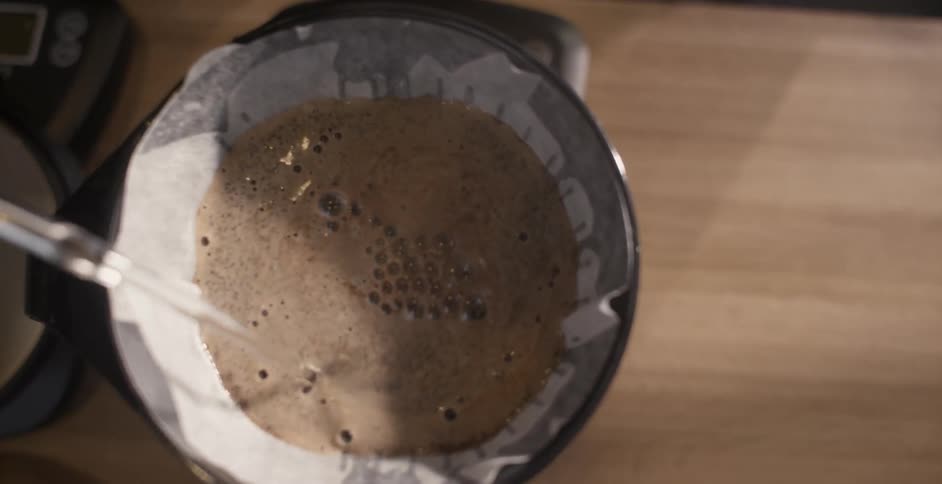 Hot water is poured from a kettle and into a coffee filter