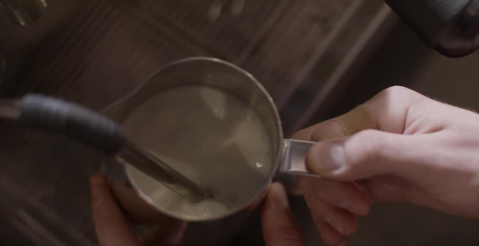 A person holds a cup as water pours into it