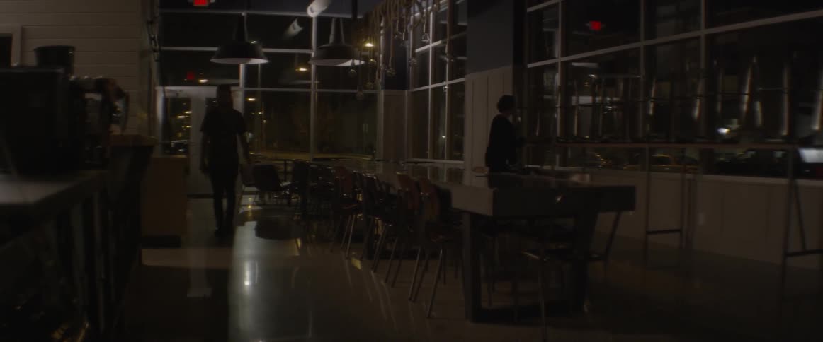 A worker pulls bar stools down getting ready to open
