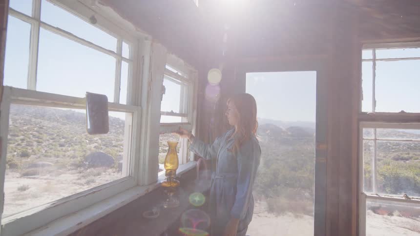 Woman burning incense opens the cabin window