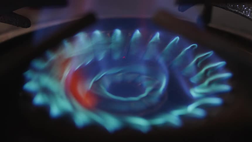Close up of a gas powered stovetop lighting up in a kitchen