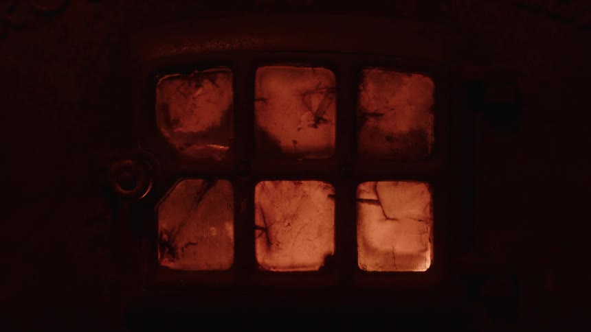 Close up of a window with a fire behind it
