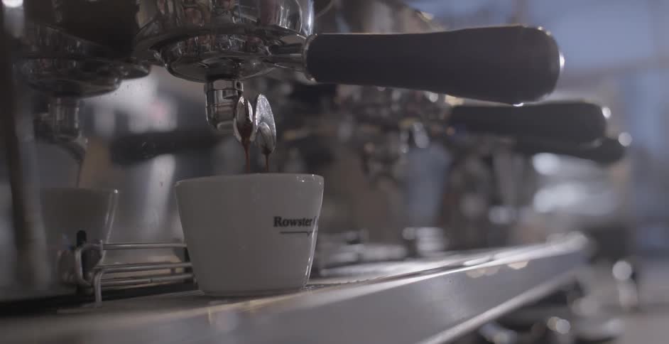 A mug is placed under the spout of a coffee machine