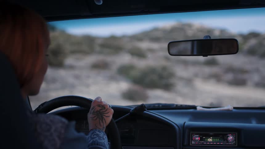 Lady place hands on the steering wheel while looking around at daytime