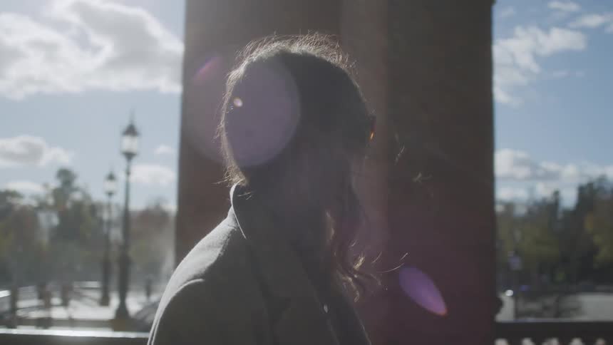 Woman walking towards an outdoor corridor with sunglasses