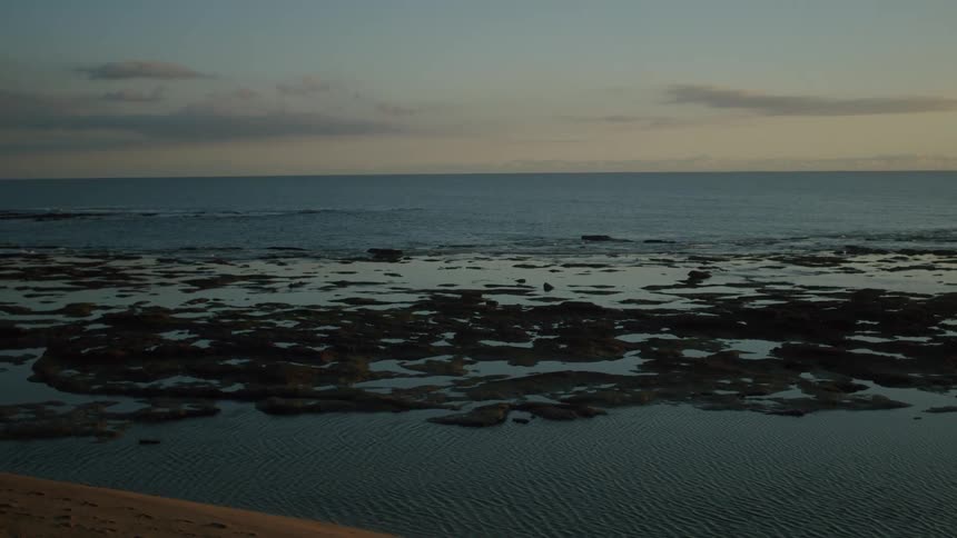 Rocks on the coast of a beach at sunset