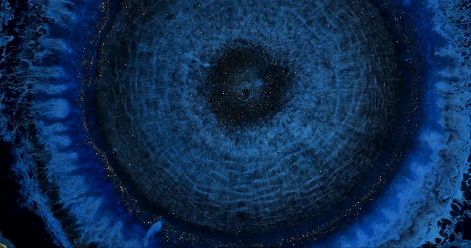 Microscopic view of electric blue fluid expanding and spreading