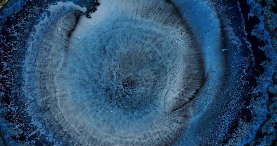 A blue liquid exploding in a circular shape and heading towards the surrounding directions