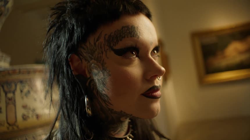 Closeup of a womans face with a tattoo and makeup