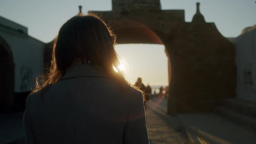 Two people walk towards the shore