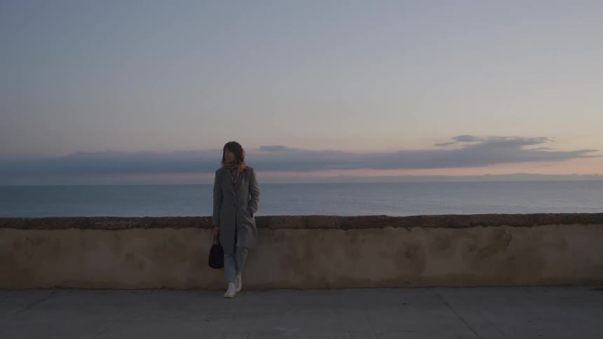A woman is leaning against the wall