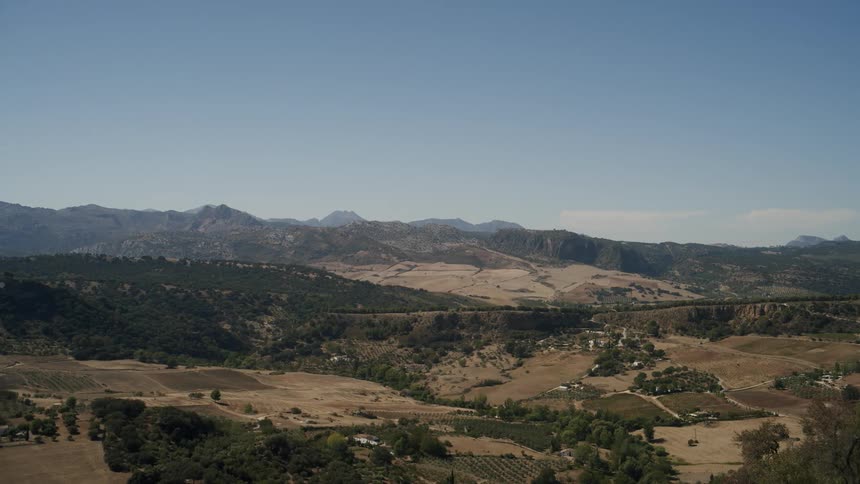 Landscape of green areas with grasslands and a mountain range in daylight
