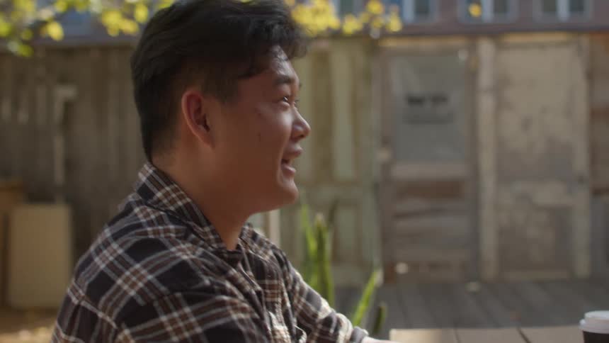 Two people sitting at a table and conversing with drinks on the table