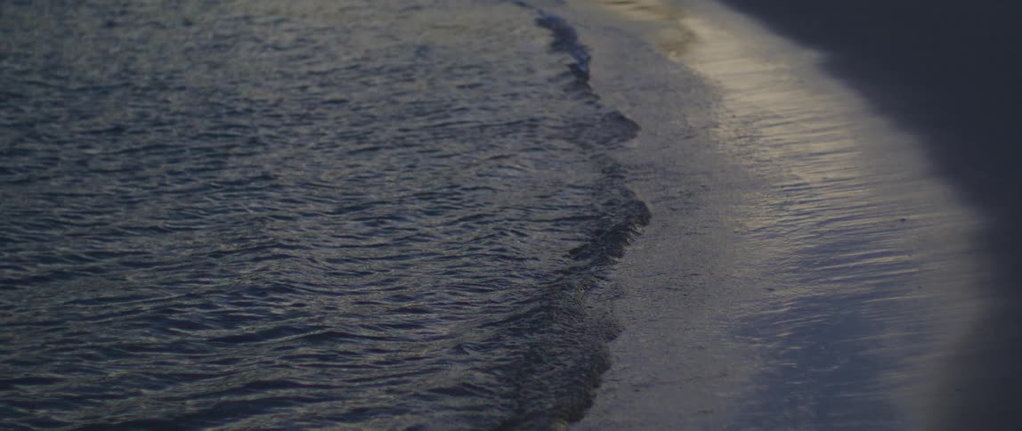 Ocean waves breaking against the sandy beach