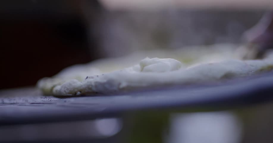 A person is cooking a pizza outside