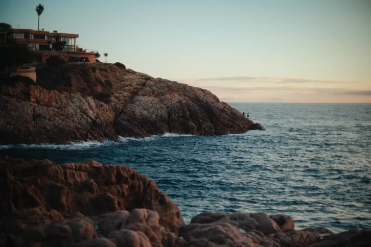 View of the sea with waves crashing along the shore under a morning sky