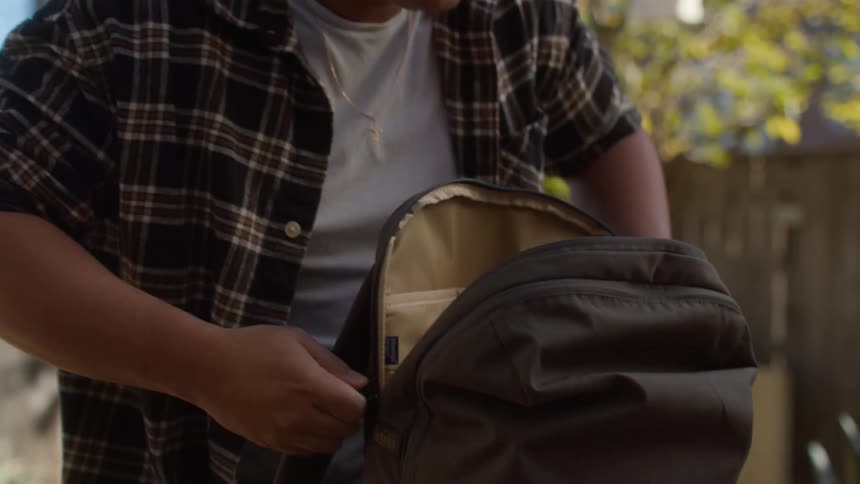 A student packs his backs in his backpack and walks off