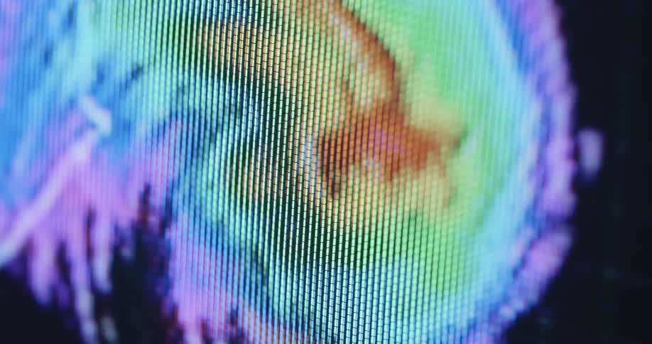 Extreme macro close up with shaky camera movement of a television screen displaying a hurricane or storm pattern animation that moves toward American coast caused by global warming and climate change