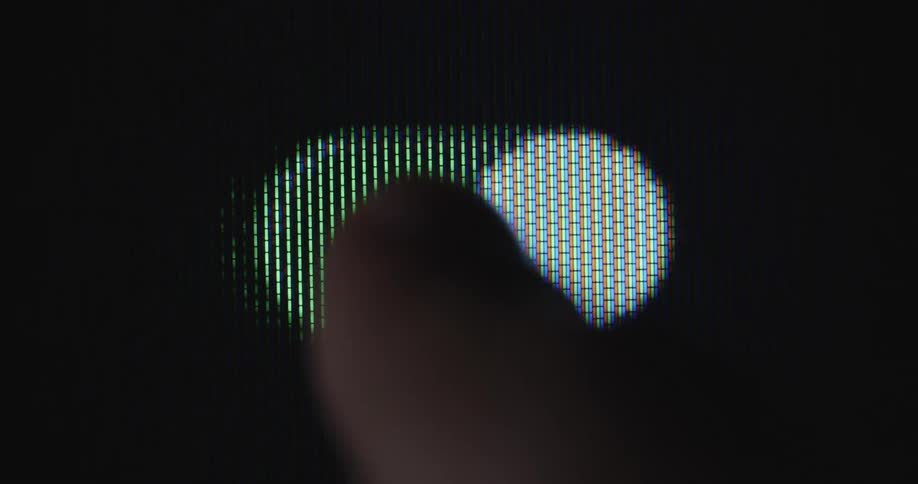 An unrecognisable person presses the green and white power or start button on the screen to activate or deactivate a feature or function of the display device he or she is using