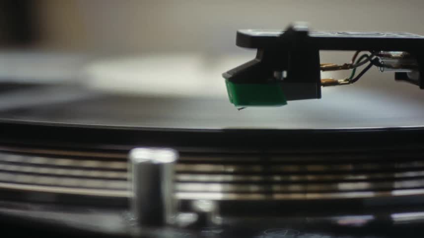 A turntable spins as the needle moves down on the record album
