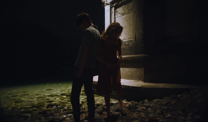 Couple stand next to a river in the city