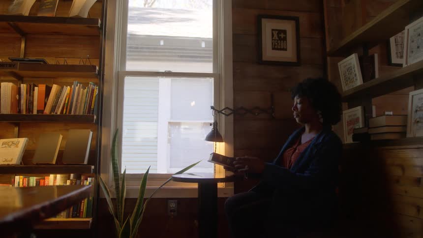 Customer sits down to read a book in a bookstore