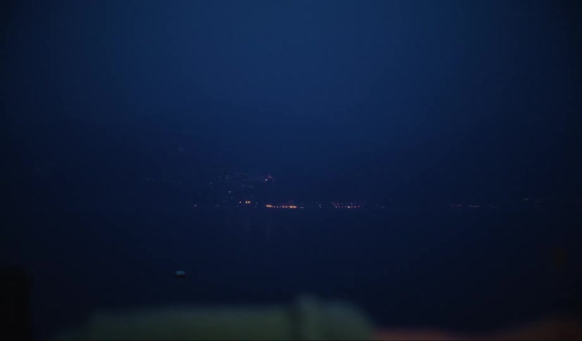 Young man looking out a window at night