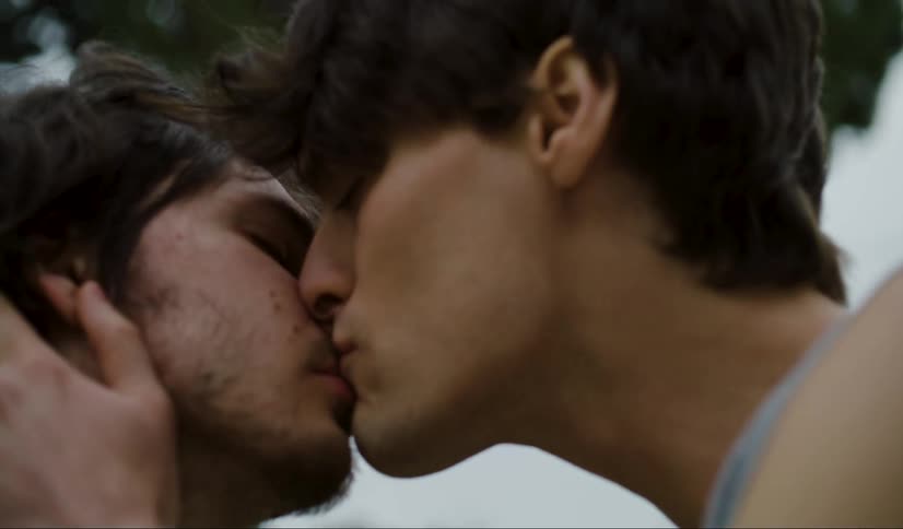 Two men kissing while standing at daytime