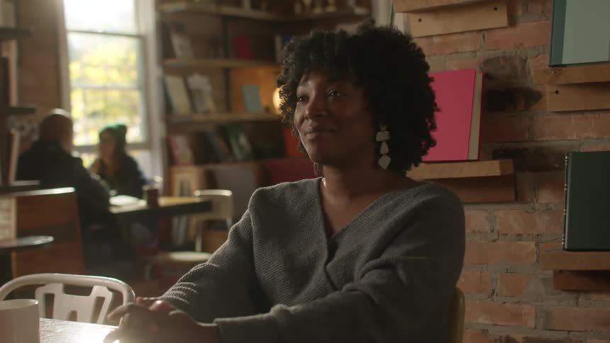 A woman is talking with someone in a cafe