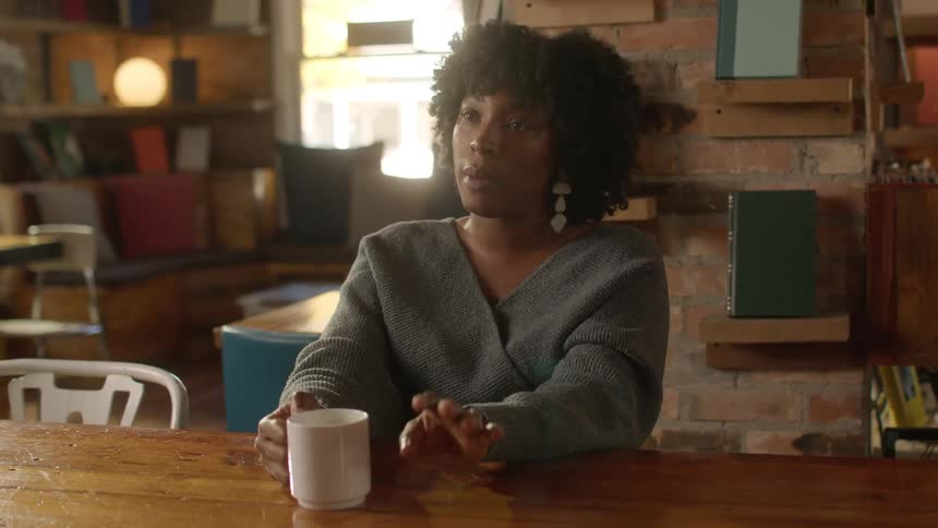 Woman talks to a friends while drinking coffee