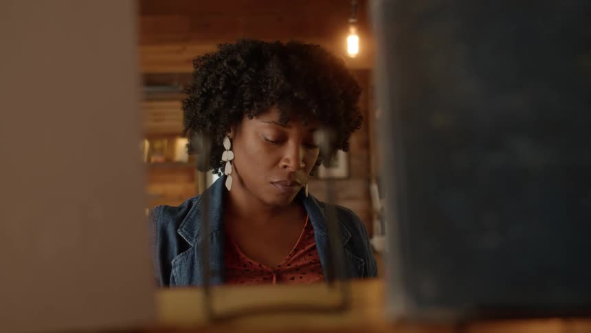 A woman takes a book from a shelf in a store and walks off