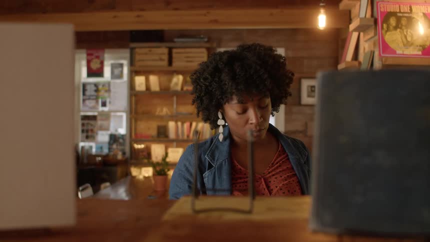 Woman shopping in bookstore picks a book