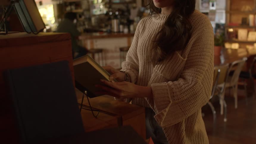 Woman browses books on a coffee store