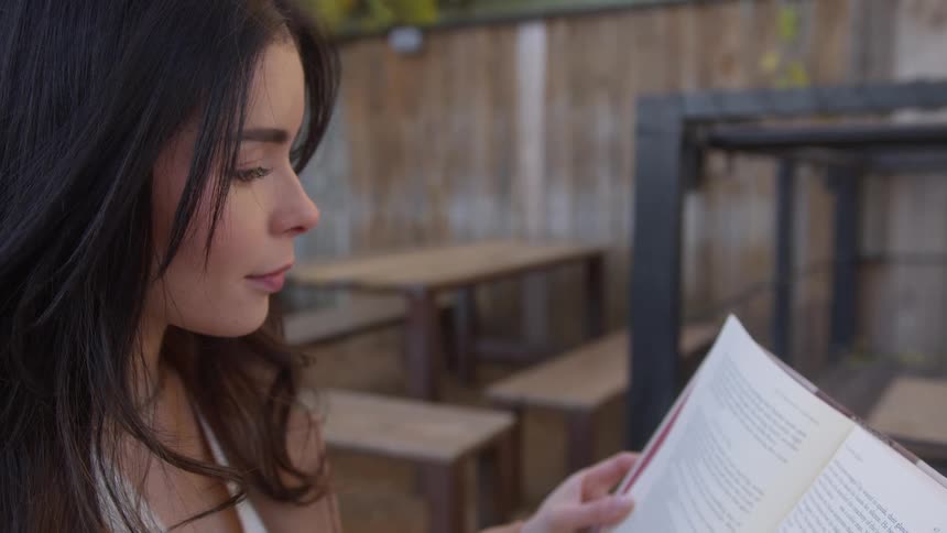 A woman is reading a book outside