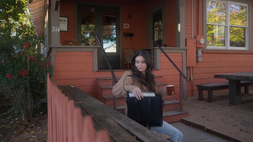 Woman sits outside a coffee shop to enjoy her drink