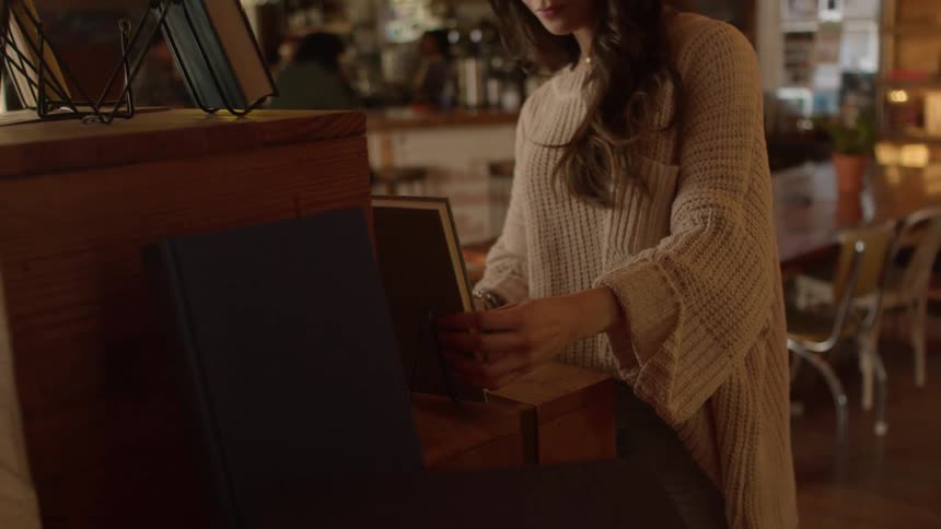 A woman lifts a book in the bar