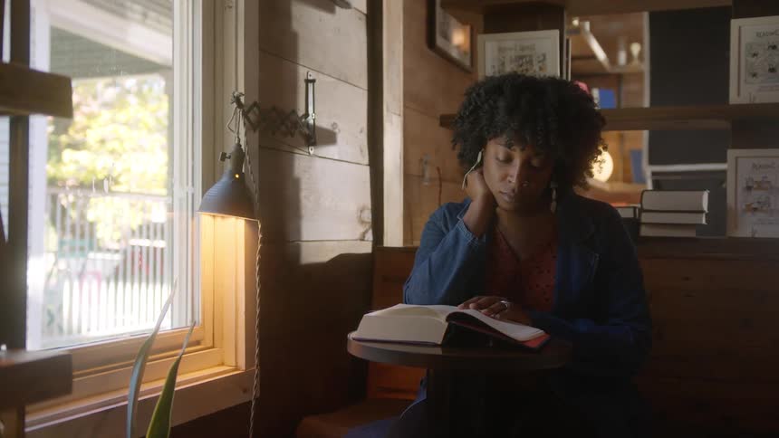 A woman is reading a book by the window