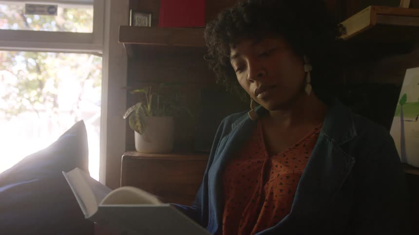 Woman reading a book at a cozy bookstore