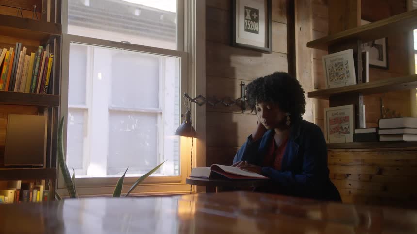 A woman is reading by the window