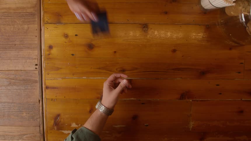 Blue credit card is handed to a food establishment employee