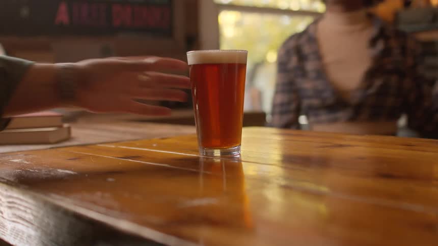 Bartender serves a beer on a bar