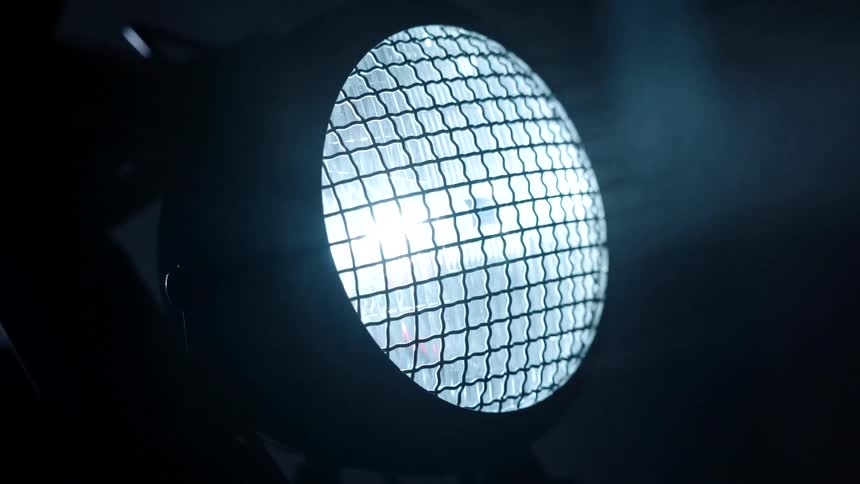 Close up of the headlight of a motorcycle at night