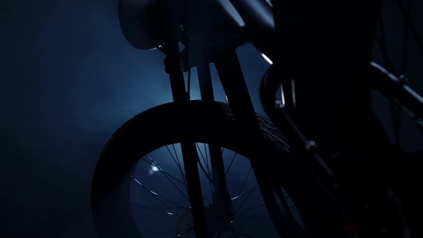 The motorcycle is parked in the dark garage