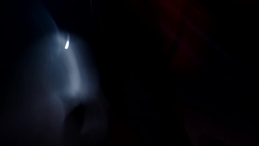 Shaky close up of a motorcycle under moving red lights